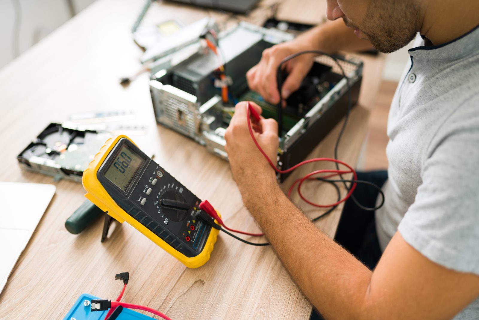 Technicien réalisant un diagnostic électrique au multimètre